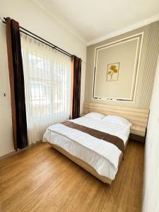 a bedroom with a large bed and a window at Villa dina in Songgoriti +11 photos