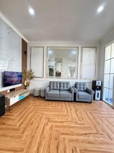 a living room with a couch and a tv at Villa dina in Songgoriti