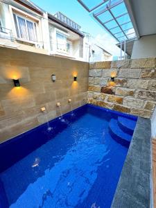 a swimming pool with blue water in a building at Villa dina in Songgoriti