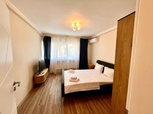 a small room with a bed and a television at Constanta Seaside Studio in Constanţa