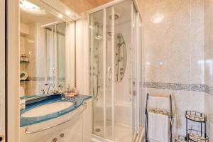 a bathroom with a tub and a glass shower at Victoria Beach Apartments in Menton