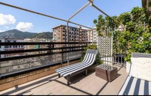 a balcony with two benches and a view of a city at Mareluna Penthouse - Luxury Suites & Rooftop in Salerno