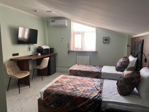 埃里温MargaryanS hotel的一间酒店房间，里面有两张床和一张桌子。