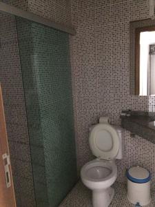 a bathroom with a toilet and a glass shower door at Inácio Palace Hotel in Rio Branco