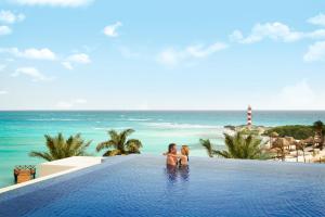 a man and a woman swimming in a pool at Turquoize at Hyatt Ziva Cancun - Adults Only - All Inclusive in Cancún