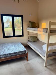 zwei Etagenbetten in einem Zimmer mit Fenster in der Unterkunft La Caballeriza in La Porteña