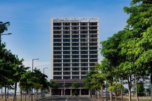 a tall building with a parking lot in front of it at The First Clark Hotel and Residence in Pampang