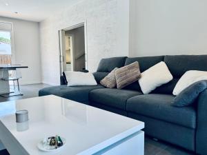 un soggiorno con divano blu e tavolo bianco di Hauzify I Casa Sa Calma a Platja  d'Aro