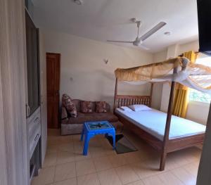1 dormitorio con litera y sofá en Haven Homes Studio Apartment, en Diani Beach 1 foto más