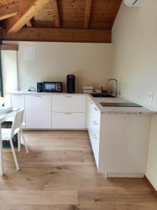 a kitchen with white cabinets and a table with a microwave at Agrialloggio Verde Fiore in Vigonza +10 photos