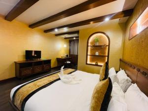 a hotel room with a bed and a tv at Timber House by Tara Group in Kathmandu