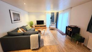 un soggiorno con un divano e una TV di Cozy forest cottage in quiet nature reserve a Emst