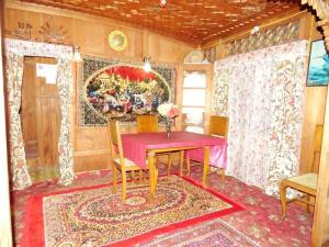 a dining room with a red table and chairs at Houseboat Young Kabul in Srinagar