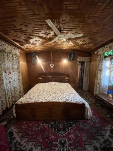 a bedroom with a large bed with a wooden ceiling at Houseboat Young Kabul in Srinagar