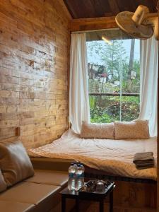 a window seat in a log cabin with a couch at Mando homestay- Venuestay in Bắc Yên +24 photos