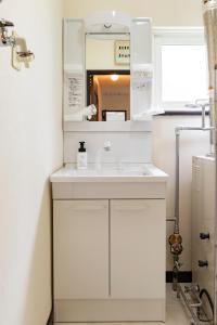 Una cocina blanca con fregadero y espejo. en Tsubaki オーシャンビュー 観光拠点 閑静な住宅街, en Otaru 69 fotos más