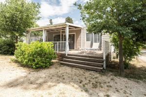 a small house with a porch and two chairs on the porch at Zaton Holiday Resort Camping Homes in Nin