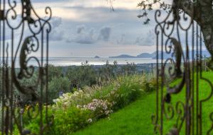 a view of the ocean from a garden through a fence at Gorgeous Home In Strettoia in Strettoia +38 photos