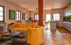 a living room with a yellow couch and a table at Gorgeous Home In Strettoia in Strettoia