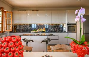a kitchen with white cabinets and a counter with a table at Gorgeous Home In Strettoia in Strettoia