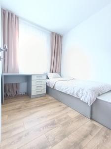 a bedroom with two beds and a desk at Connected in Brčko
