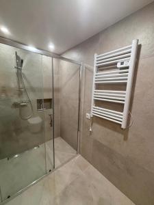 y baño con ducha y cabina de ducha acristalada. en Apartament pod lasem 2, en Nowy Targ