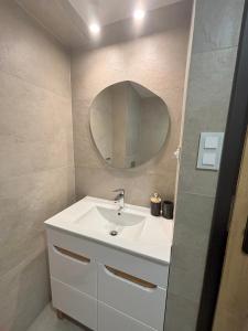 Un baño con un lavabo blanco y un espejo. en Apartament pod lasem 2, en Nowy Targ