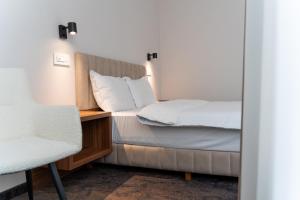 a bedroom with two beds and a chair at Embassy Romana in Bucharest +58 photos