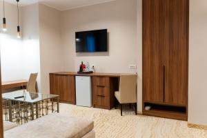 a living room with a table and a kitchen at Embassy Romana in Bucharest