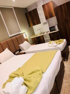 two beds in a hotel room with yellow sheets at Résidence touristique marcadal in Fort de lʼEau