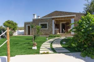 uma casa com um caminho de pedra em frente a um quintal em Hort den Pilot em Sant Rafael de Sa Creu