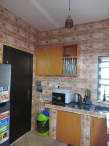 a kitchen with wooden walls and a counter with a microwave at Gigiswhitehouse in Cardoso