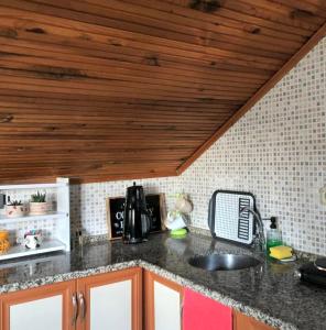 a kitchen counter with a sink and a wooden ceiling at Deka apartments 7 in Fethiye