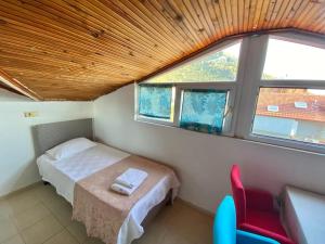 a bedroom with a bed and a chair and a window at Deka apartments 7 in Fethiye