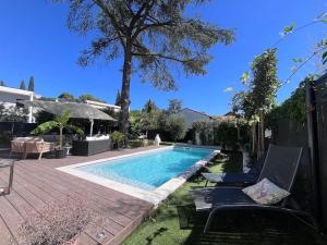 einen Pool mit zwei Stühlen neben einem Haus in der Unterkunft Superbe villa avec piscine in Castelnau-le-Lez