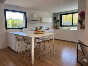 eine Küche mit einem Tisch mit Stühlen und einer Arbeitsplatte in der Unterkunft Superbe villa avec piscine in Castelnau-le-Lez