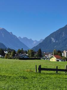 a fence in a field with mountains in the background at Ferienwohnung Tiroler Auszeit & Whirlpool in Hofen