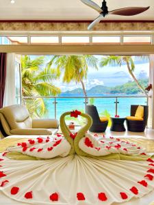 a room with a large bed with roses on it at Villa Chez Batista in Takamaka