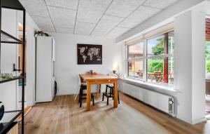 comedor con mesa de madera y ventanas en 3 Bedroom Cozy Home In Billund, en Billund