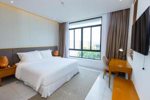 Schlafzimmer mit einem Bett, einem Schreibtisch und einem großen Fenster in der Unterkunft Ocean Breeze Villa Cam Ranh in Cam Ranh + 32 Fotos