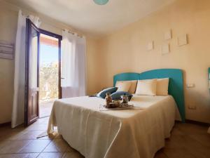 una camera da letto con un letto grande con testiera blu di Casa Lisa Agorà mare e relax a Villasimius
