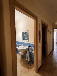 un bagno con lavandino bianco e piastrelle blu di Casa Lisa Agorà mare e relax a Villasimius