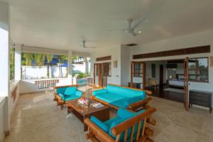a living room with blue couches and a table at Baan Angelo 3 Bed Private Pool Villa, Kata Hill in Ban Kata