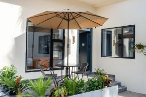 a patio with a table and chairs and an umbrella at Qiyunju Hotel-24H Free Airport Pickup Drop-off in Shanghai
