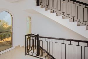 拉斯阿尔卡麦The Bramble House的带有白色墙壁和黑色栏杆的楼梯