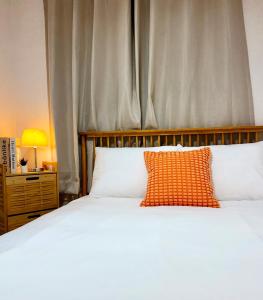 a bedroom with a white bed with an orange pillow at Seoul Gate Stay in Seoul
