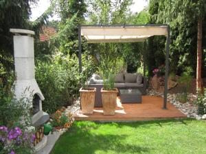 un jardin avec un canapé sous une pergola dans l'établissement Ferienwohnung Zoll, à Unterkirnach