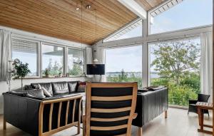 uma sala de estar com um sofá e algumas janelas em Gorgeous Home In Haderslev With Sauna em Årøsund