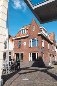 アルクマールにあるBoutique Studio VO38の時計付きの大きなレンガ造りの建物