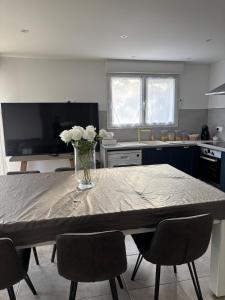 a kitchen with a table with a vase of flowers on it at Maison à la montagne in Castanet-le-Haut